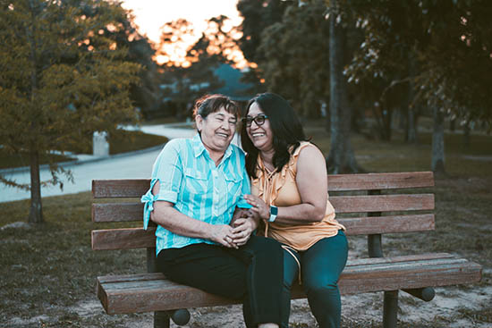 women laughing on bench